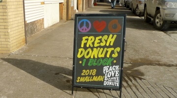 Peace, Love & Little Donuts' sidewalk sign in Pittsburgh's Strip District