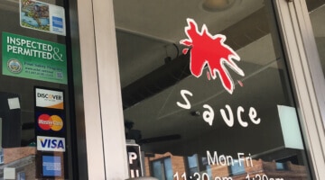 The front window and door of Sauce restaurant in Bridgeville.