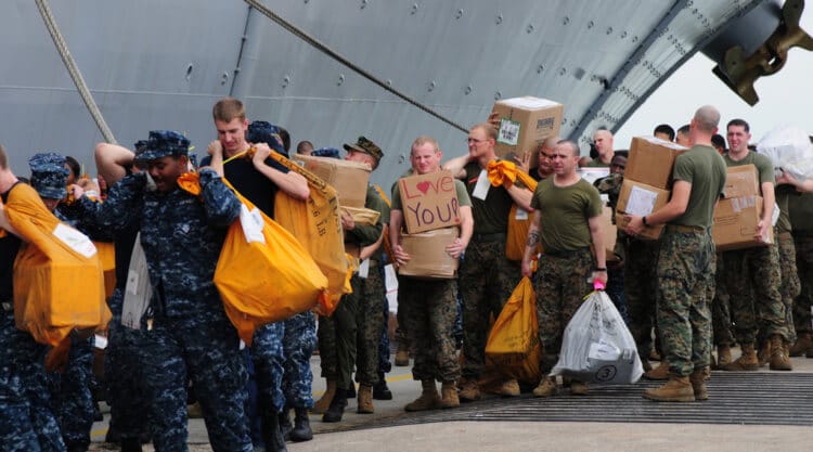 Sailors and Marines move mail onto the amphibious assault ship USS Makin Island.