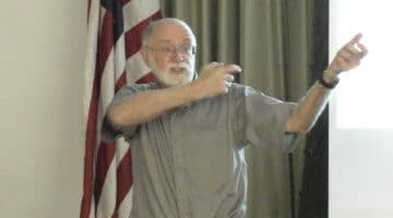Historian Edward Hale mimics a man firing a shotgun