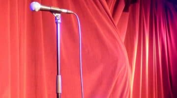 A microphone in front of a stage curtain.