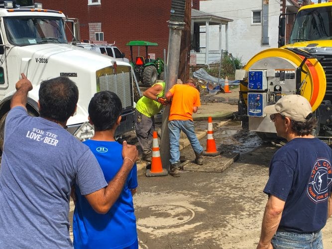 Workers clear debris from a sewer on Saturday, June 23, 2018.